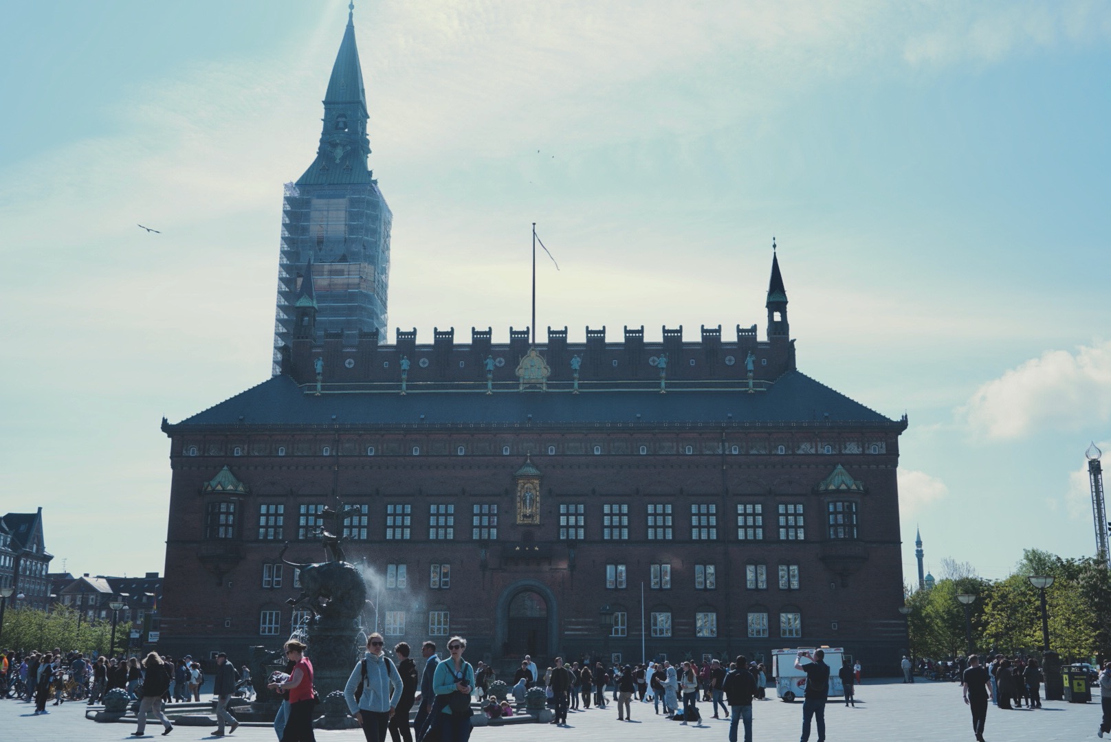 Copenhagen city hall in the morning in backlight. Dozens of people on the square.